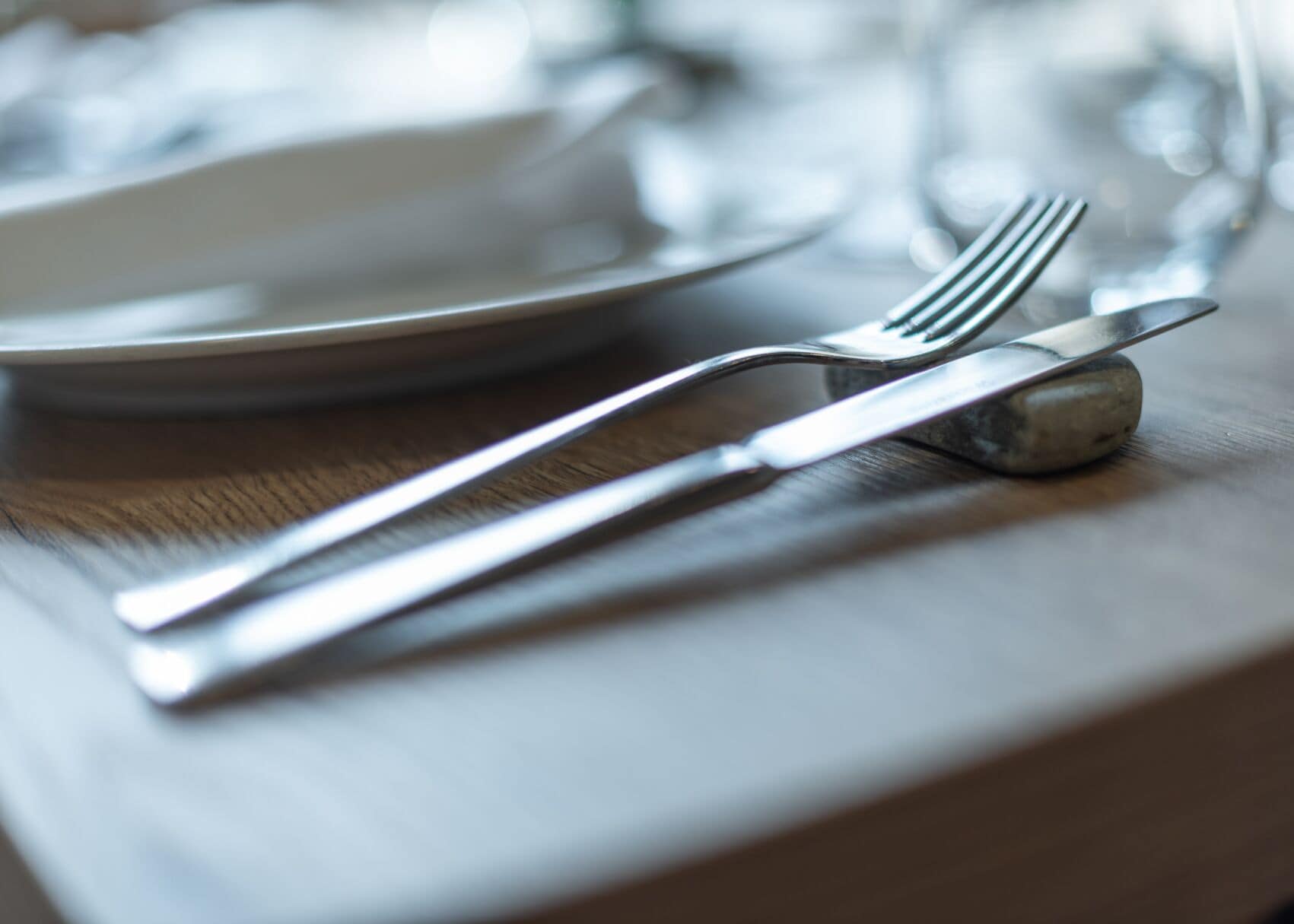Una mesa de comedor con un tenedor, un cuchillo y un salero.