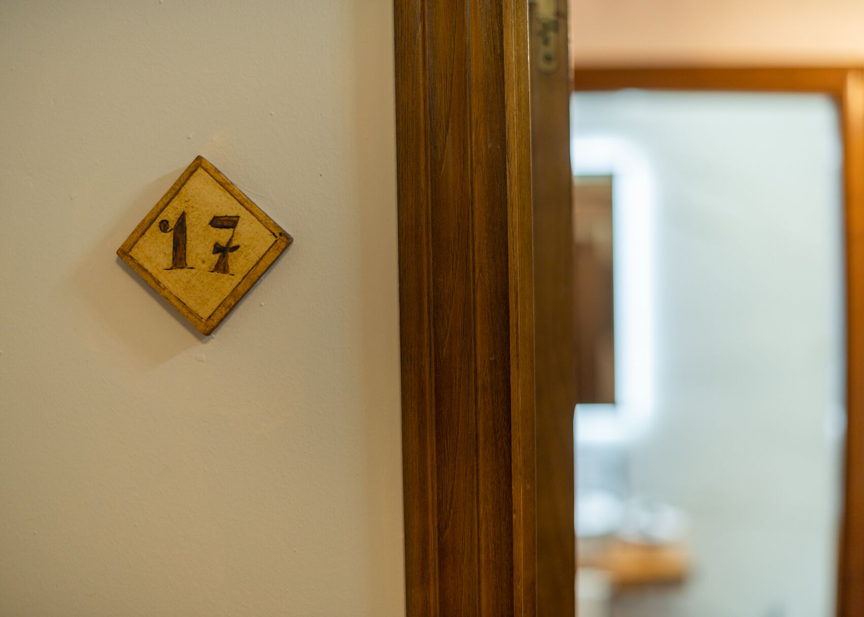 A wooden door frame with a number plaque on the wall.