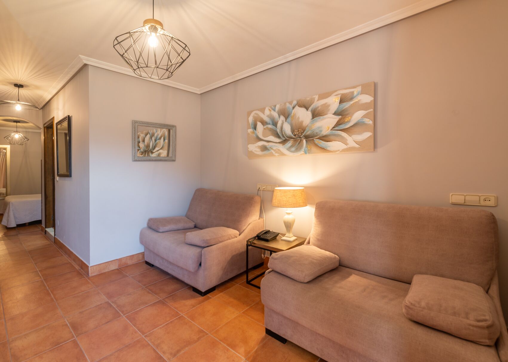 A living room with two sofas, a lamp, and a painting on the wall.