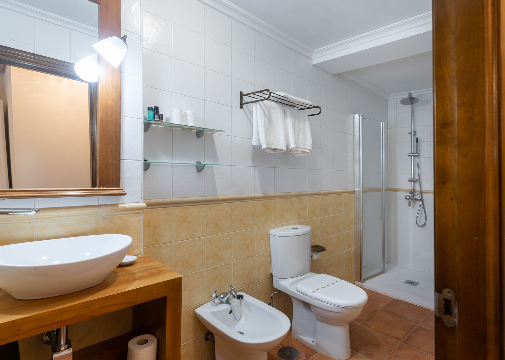 A modern bathroom with a large sink, toilet, bidet, and shower.