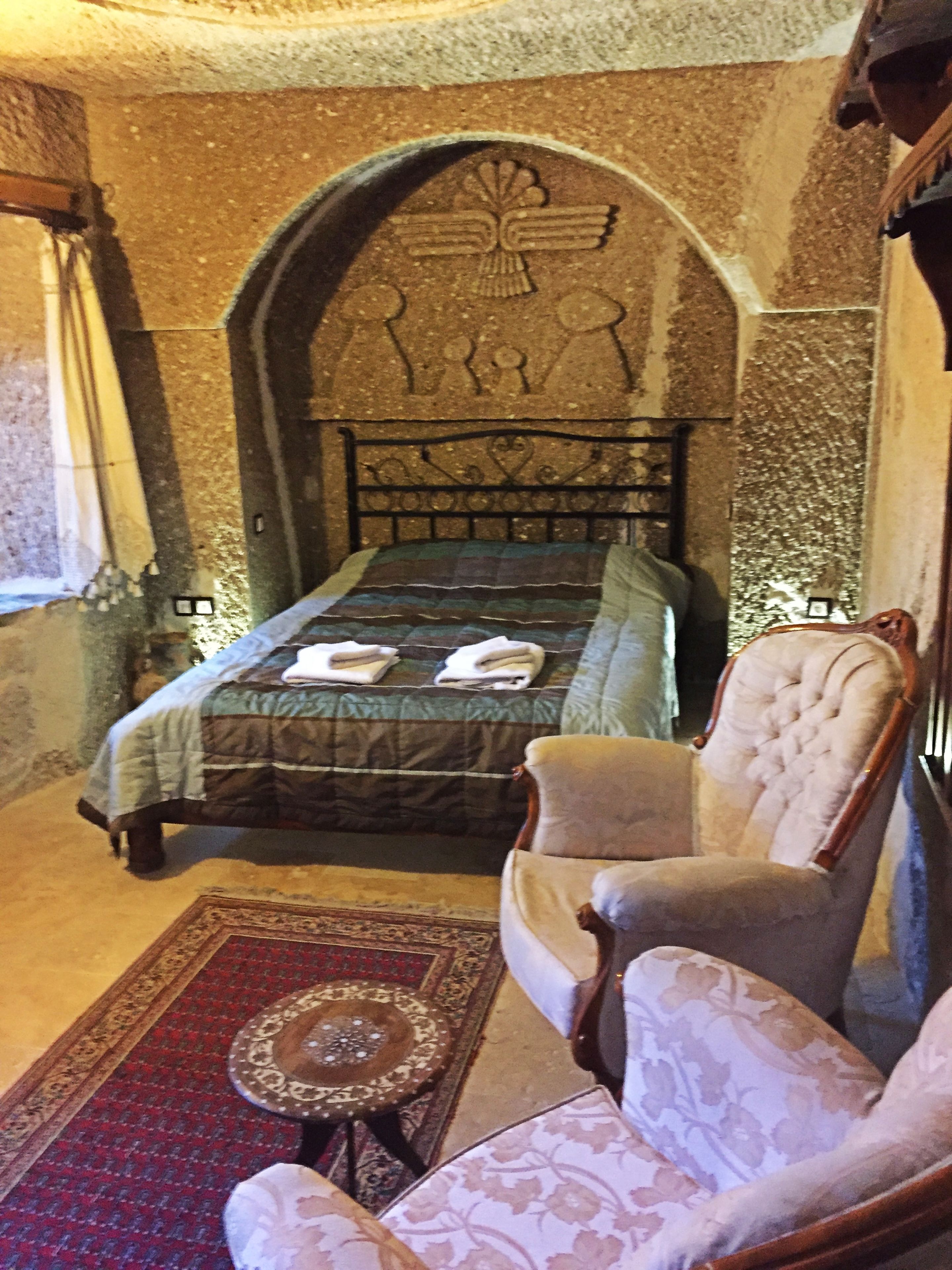 A room with a bed, a chair, and a decorative wall.