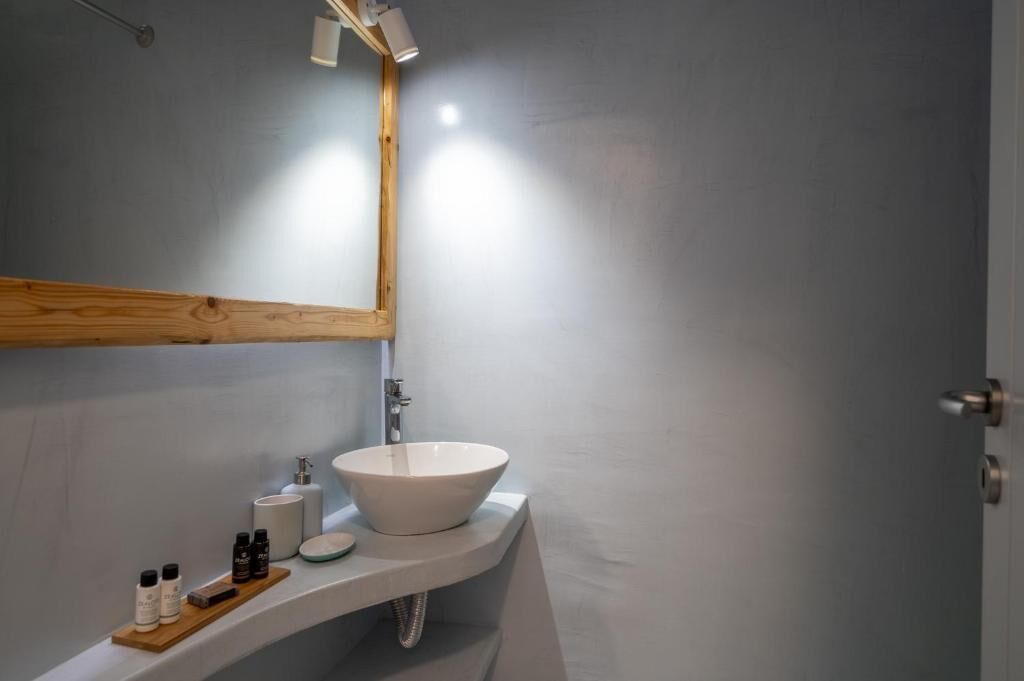 A bathroom with a white sink, a wooden-framed mirror, and a towel rack.