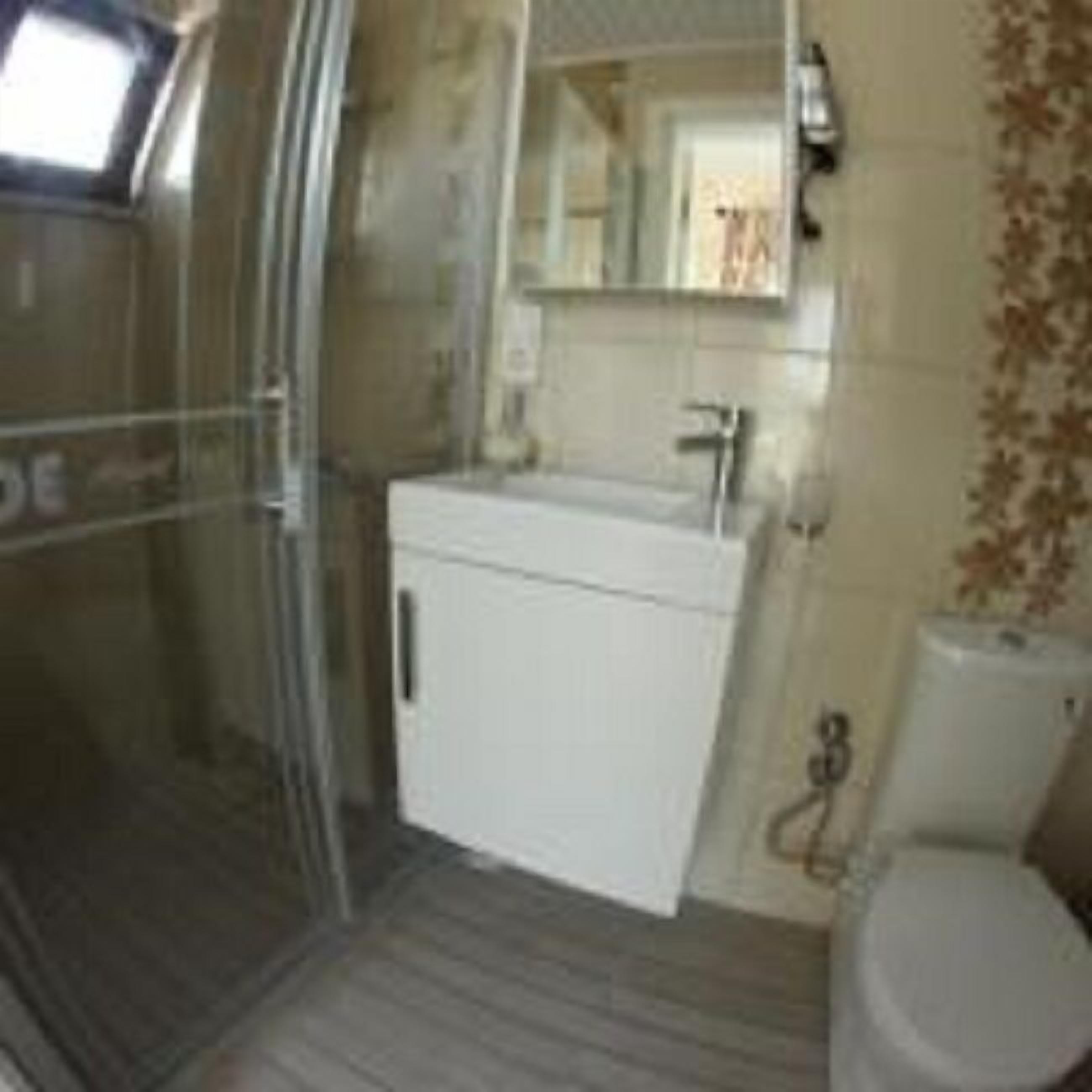A bathroom with a shower, toilet, and sink.