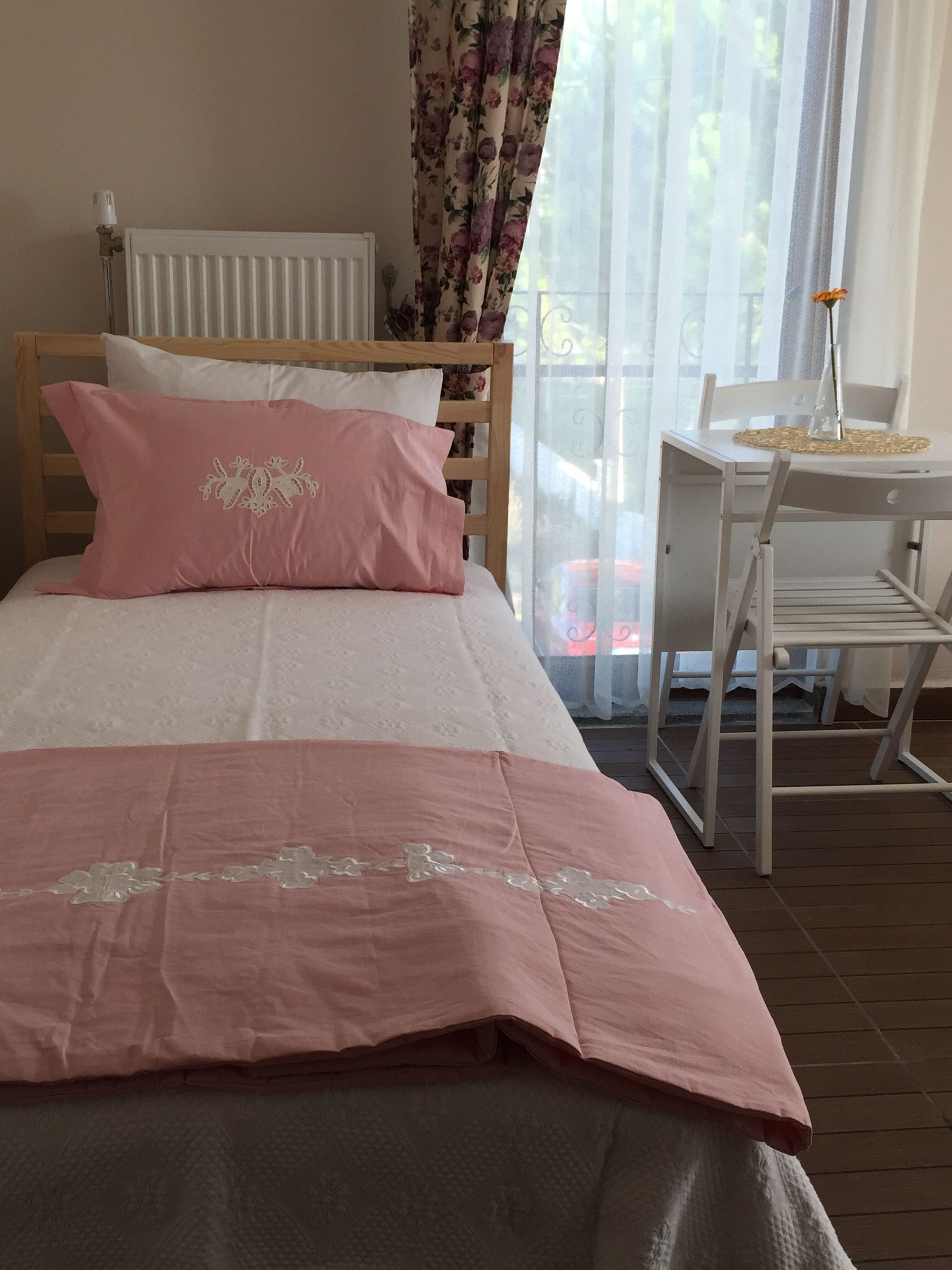 A bedroom with a bed, a desk, and a chair.