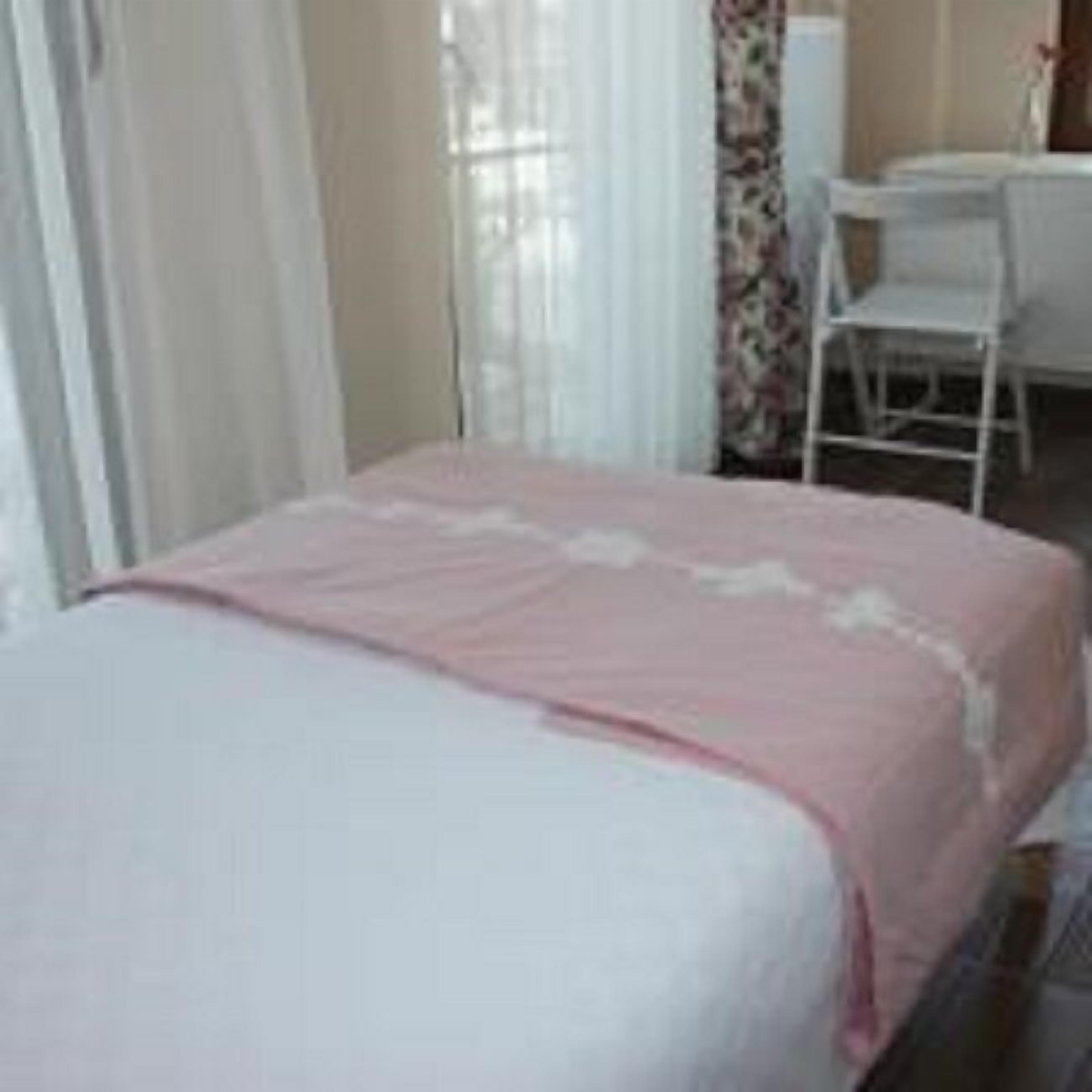 A bedroom with a bed, a chair, and a desk.