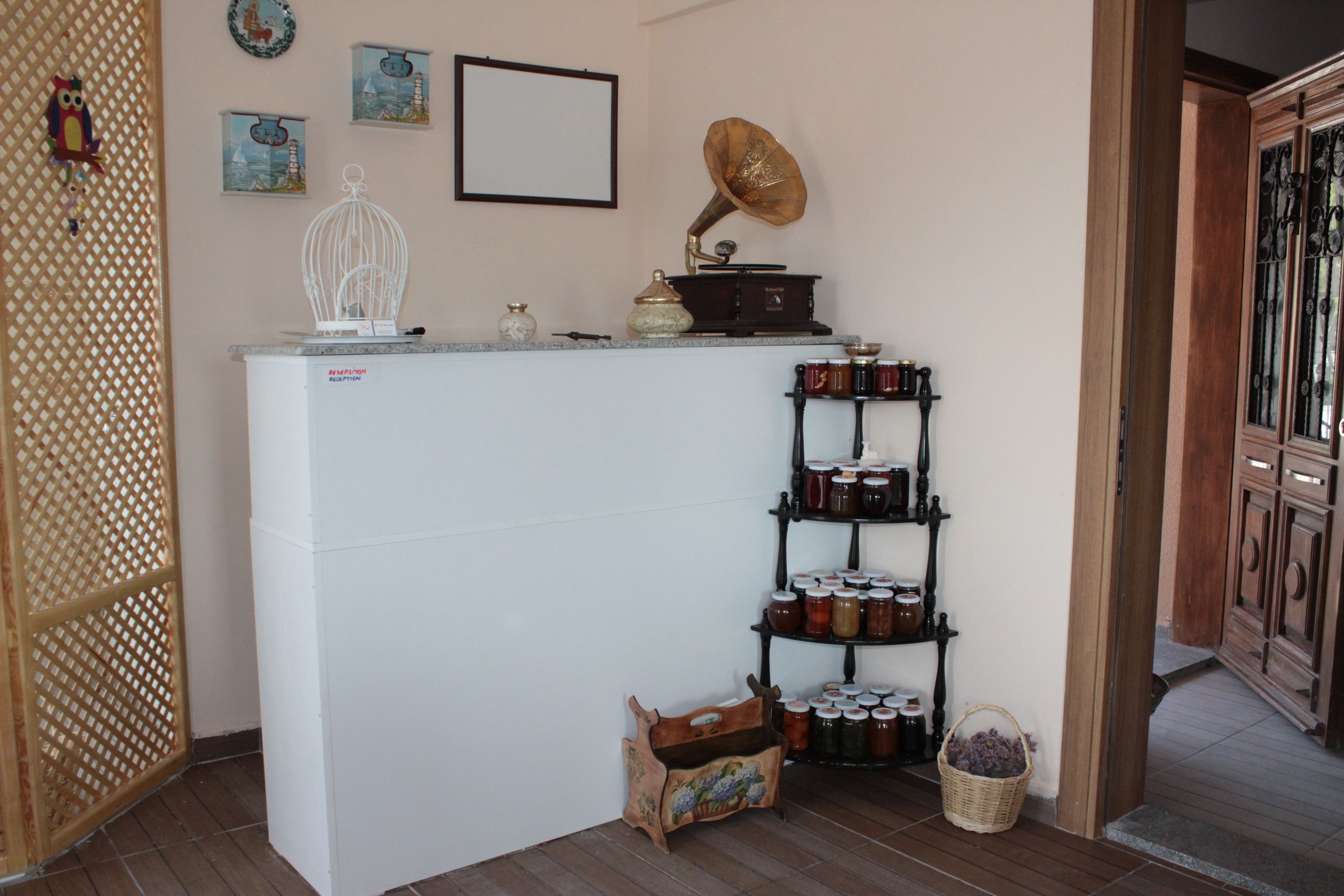 A compact kitchen with a white refrigerator, a wooden cabinet, and a shelf with jars.