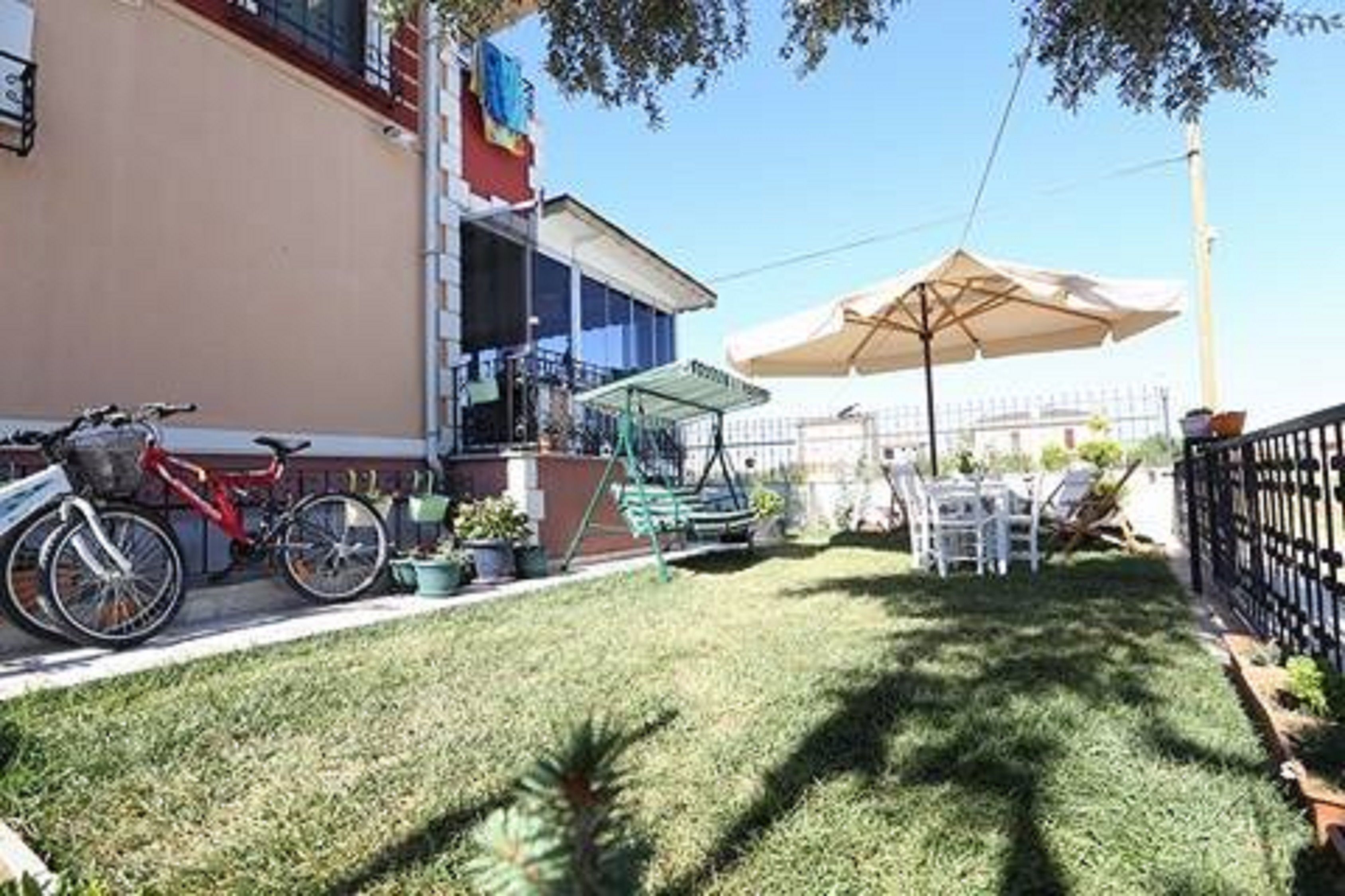 A patio area with a bicycle, outdoor furniture, and a large umbrella.