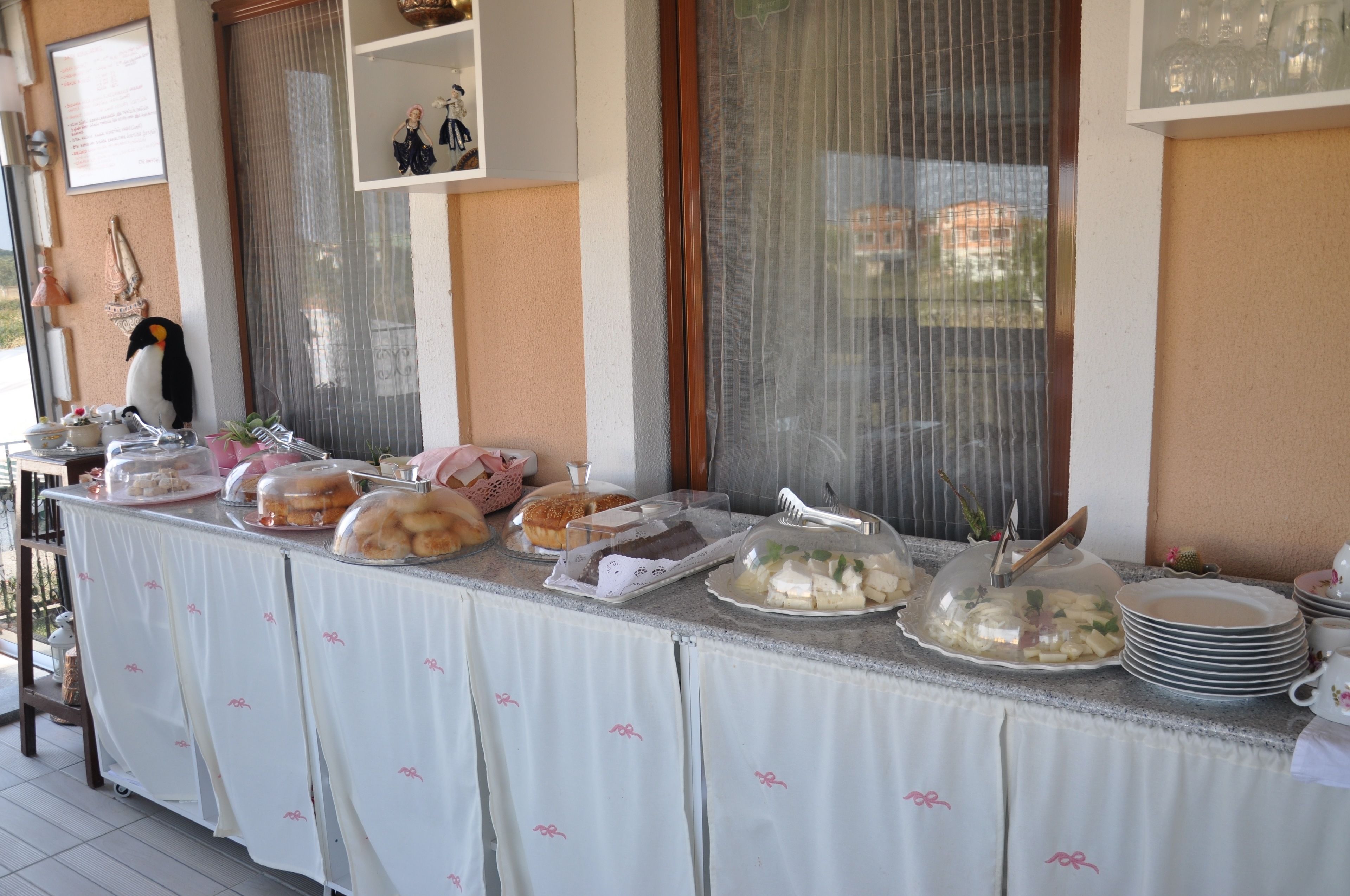 A buffet table with various food items and a penguin decoration.