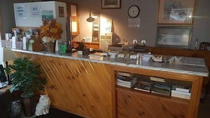 Una recepción con detalles de madera, un reloj, cuadros en la pared y una planta en maceta.