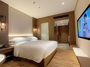 A modern hotel room with a large bed, bedside table, and a television mounted on the wall. - Chaozhou Hotel (CHAOZHOU)
