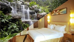 A hotel room with a bed, bedside table, and a painting on the wall. - Dreamland Hotel Huizhou (Huizhou)