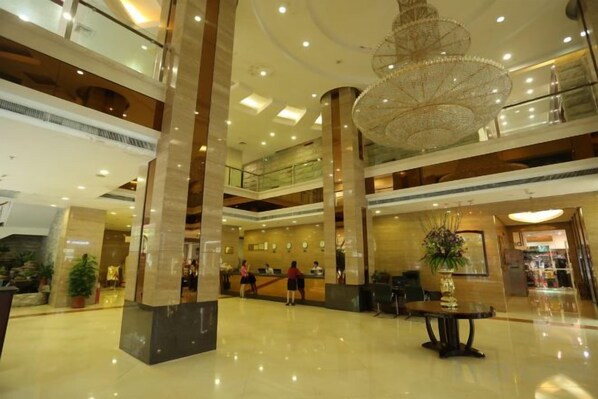 A spacious lobby with high ceilings, a grand chandelier, and multiple levels with glass railings. - Dreamland Hotel Huizhou (Huizhou)