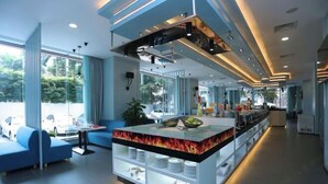 A modern hotel lobby with a central island counter, seating area, and large windows offering a view of the outdoors. - Dreamland Hotel Huizhou (Huizhou)