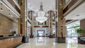 A spacious lobby with a central chandelier, a reception desk, and a view of the outside through large windows. - Dreamland Hotel Huizhou (Huizhou)