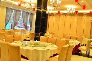 A dining area with round tables, chairs, and chandeliers. - Dreamland Hotel Huizhou (Huizhou)