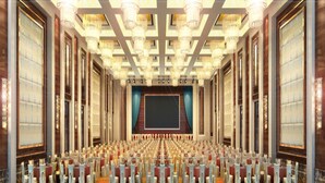 A large conference room with rows of tables and chairs, a stage with a large screen, and ornate chandeliers. - Xin Jun Yue Hotel (Foshan)