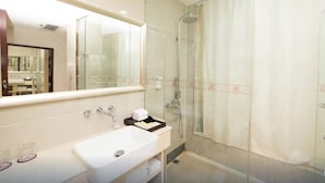 A modern bathroom with a glass-enclosed shower, a large mirror, and a white sink. - Haili Business Hotel - Zhuhai (ZHUHAI)