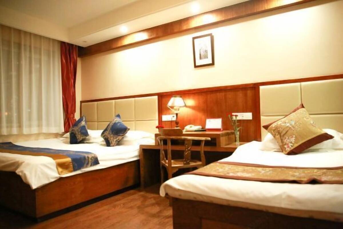 Habitación de hotel con dos camas, un escritorio y una silla.