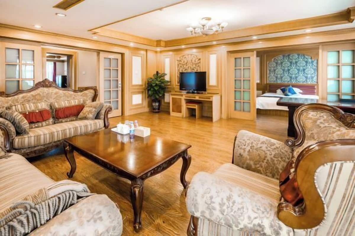 Un amplio salón con una gran mesa de centro de madera, sofás cómodos y un televisor.