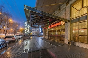 A hotel entrance with a covered walkway, a large window, and a visible entrance door. - Jinsui Hotel (Hohhot)