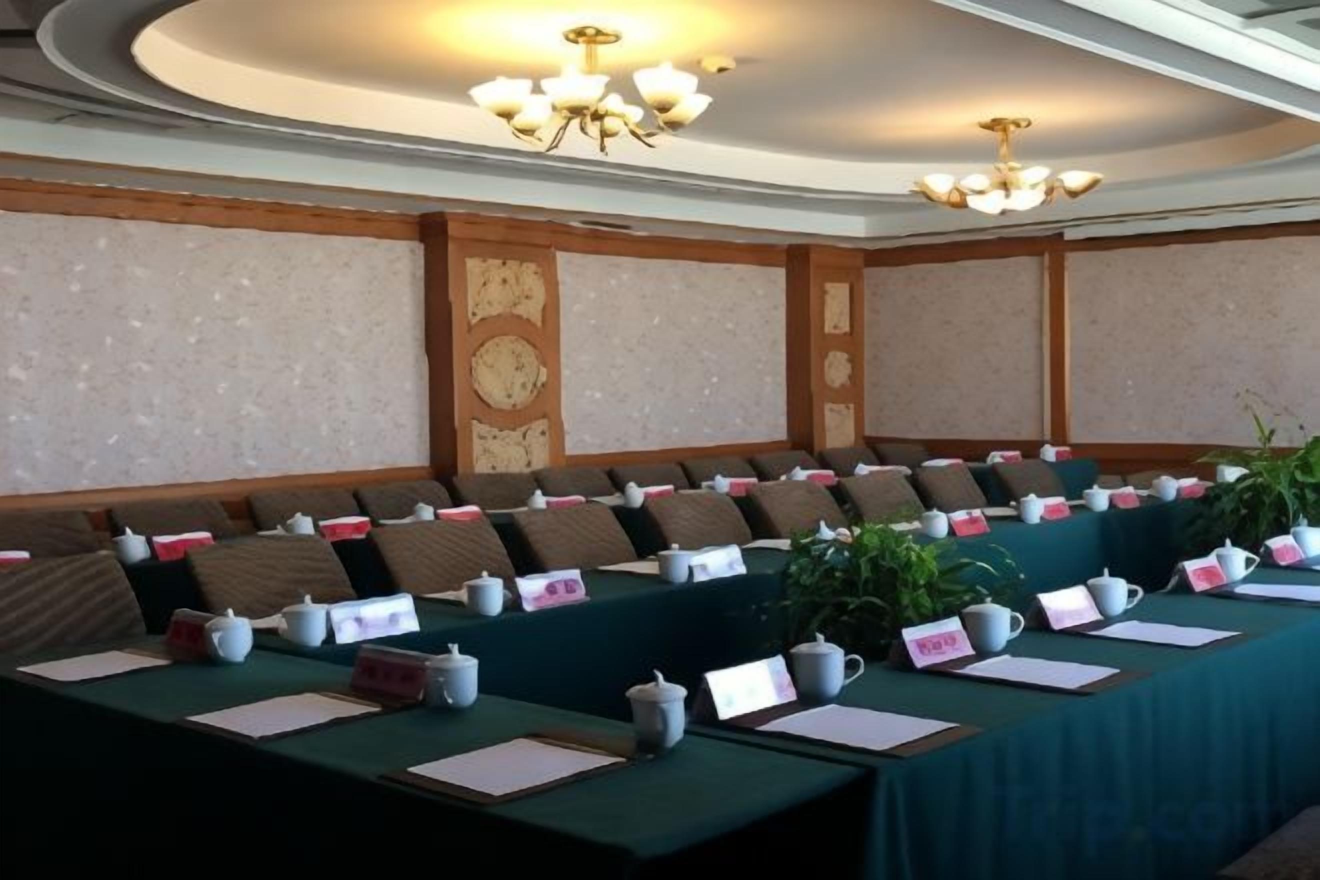 A conference room with a long table, chairs, nameplates, and teapots.