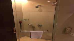 A glass-enclosed shower area with a handheld showerhead, a handheld showerhead, and a towel rack with a towel. - Borrman Hotel Dongguan Changping Avenue (Dongguan)