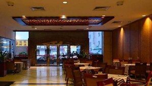 A hotel lobby with a central seating area, a reception desk, and a view of the street through large glass doors. - Borrman Hotel Dongguan Changping Avenue (Dongguan)