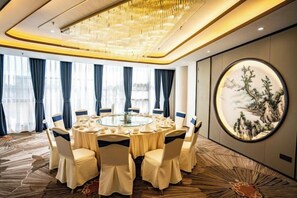 Ein Konferenzraum mit rundem Tisch, Stühlen und einer Chandelier.