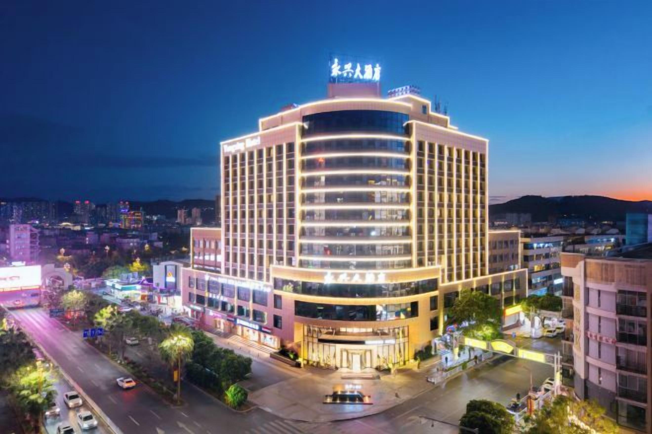 A multi-story hotel with a prominent entrance and a large sign at the top.
