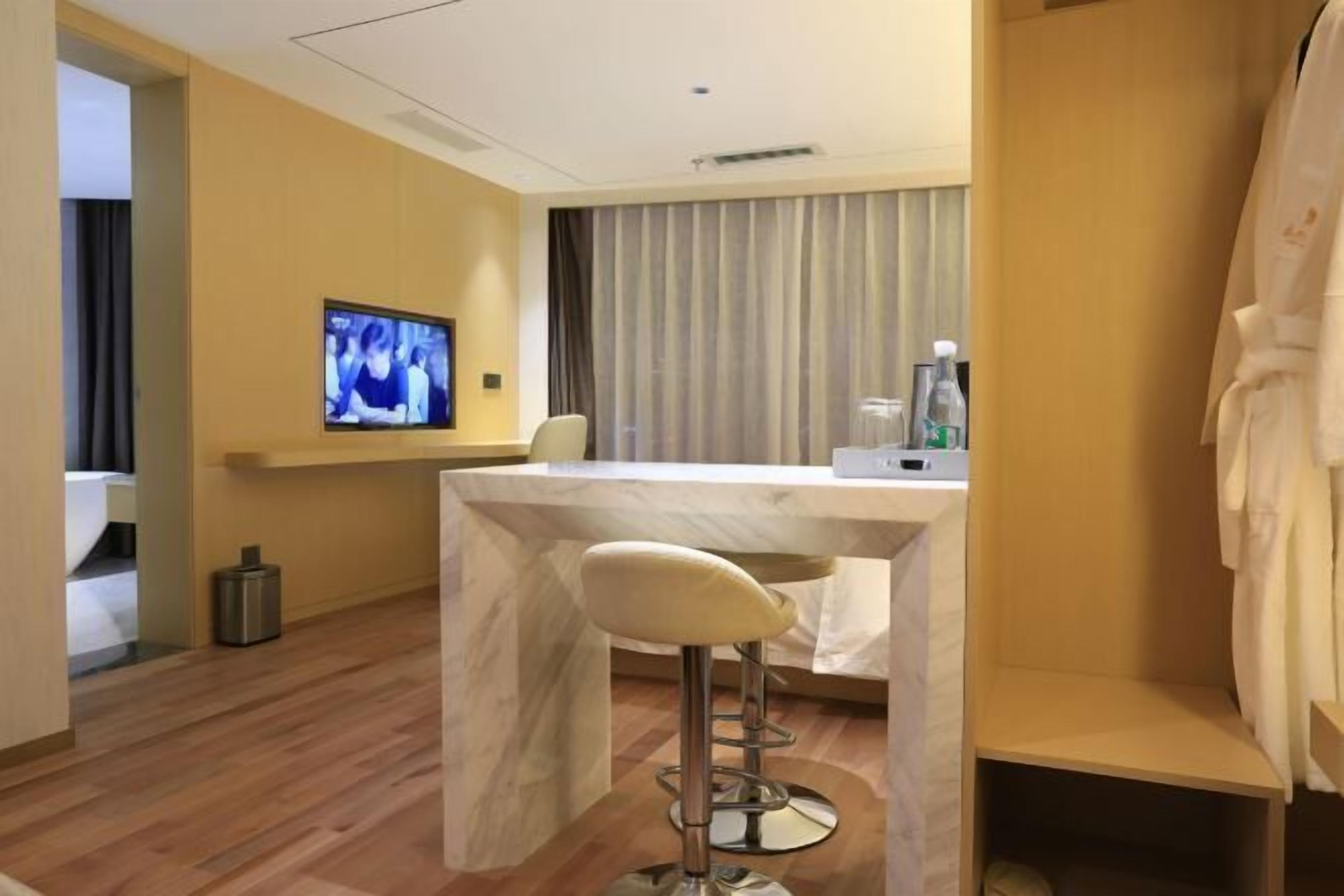 Ein Hotelzimmer mit einer Marmorbar, einem an der Wand befestigten Fernseher und einem kleinen Mülleimer.