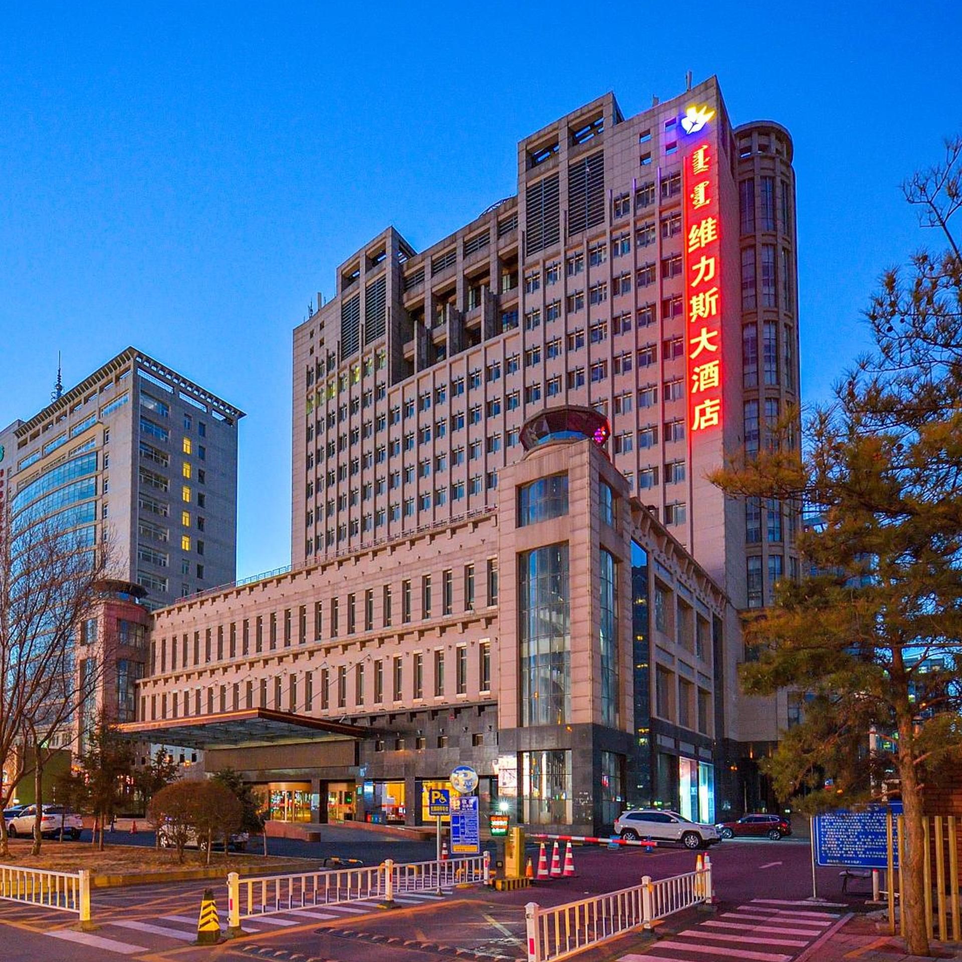 A multi-story hotel with a prominent vertical sign on the facade.