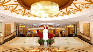 A grand lobby with a marble floor, a large chandelier, and a reception desk. - Uiles Hotel (Hohhot)