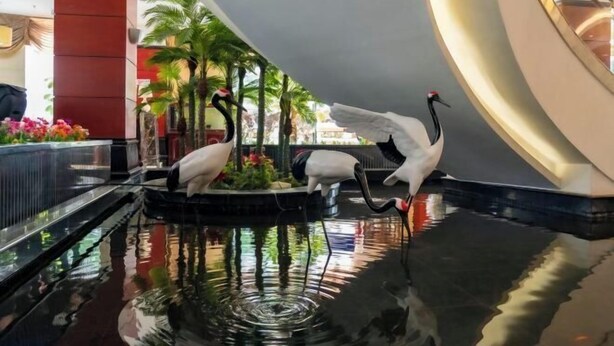 Una fuente decorada con esculturas de aves en un ambiente interior moderno.