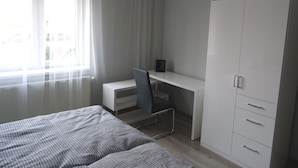 A bedroom with a bed, a desk, and a wardrobe. - Alisa Apartments (Kostomlaty nad Labem)