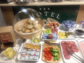 A buffet table with various food items including bread, eggs, yogurt, and deli meats. - Hotel Orient Zagreb (Zagreb)