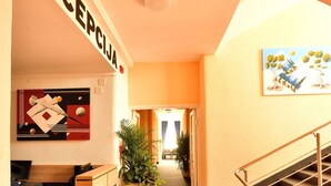 A reception area with a desk, a potted plant, and a staircase. - Hotel Orient Zagreb (Zagreb)
