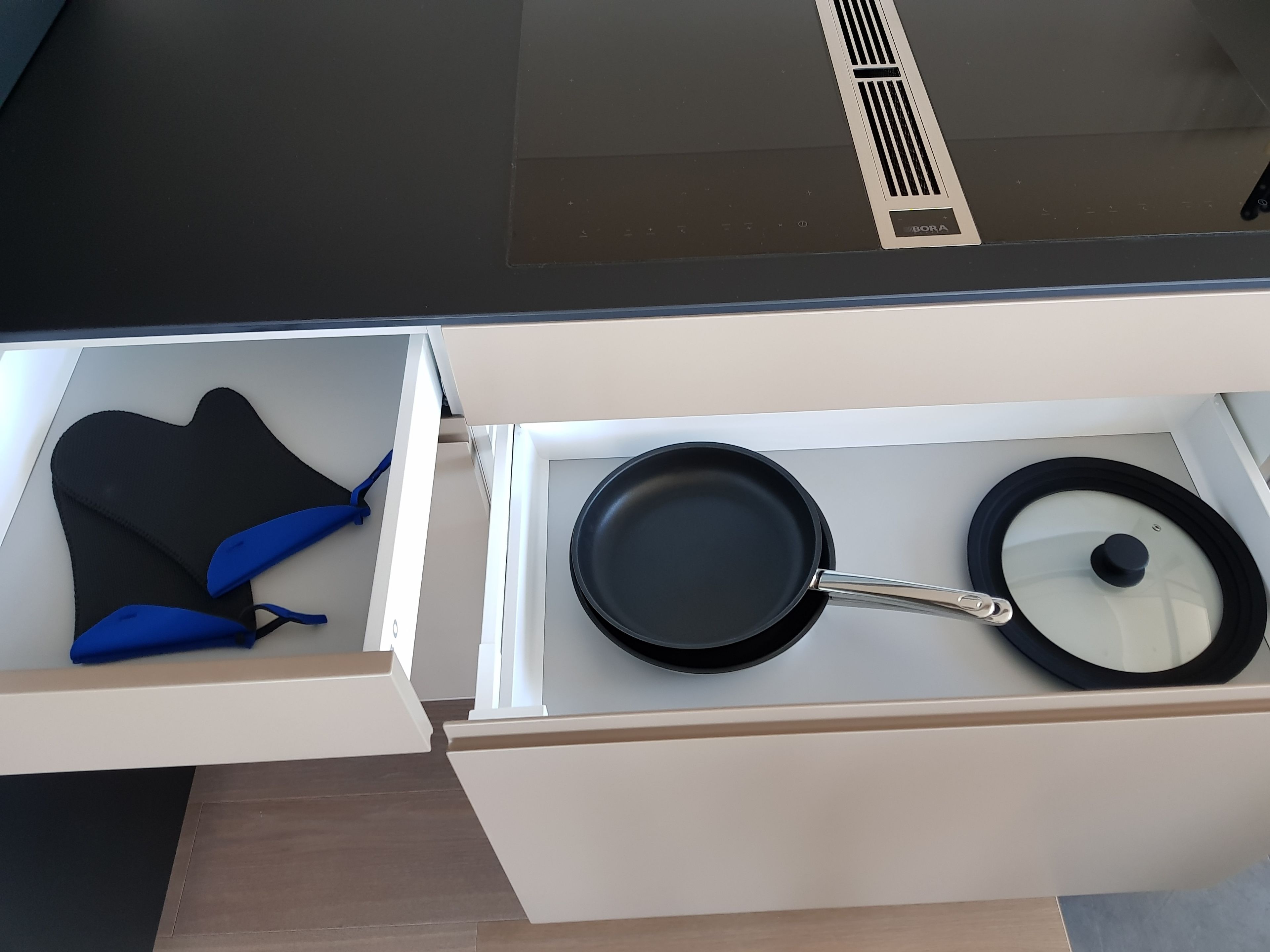 A kitchen drawer containing a black frying pan and a pot.