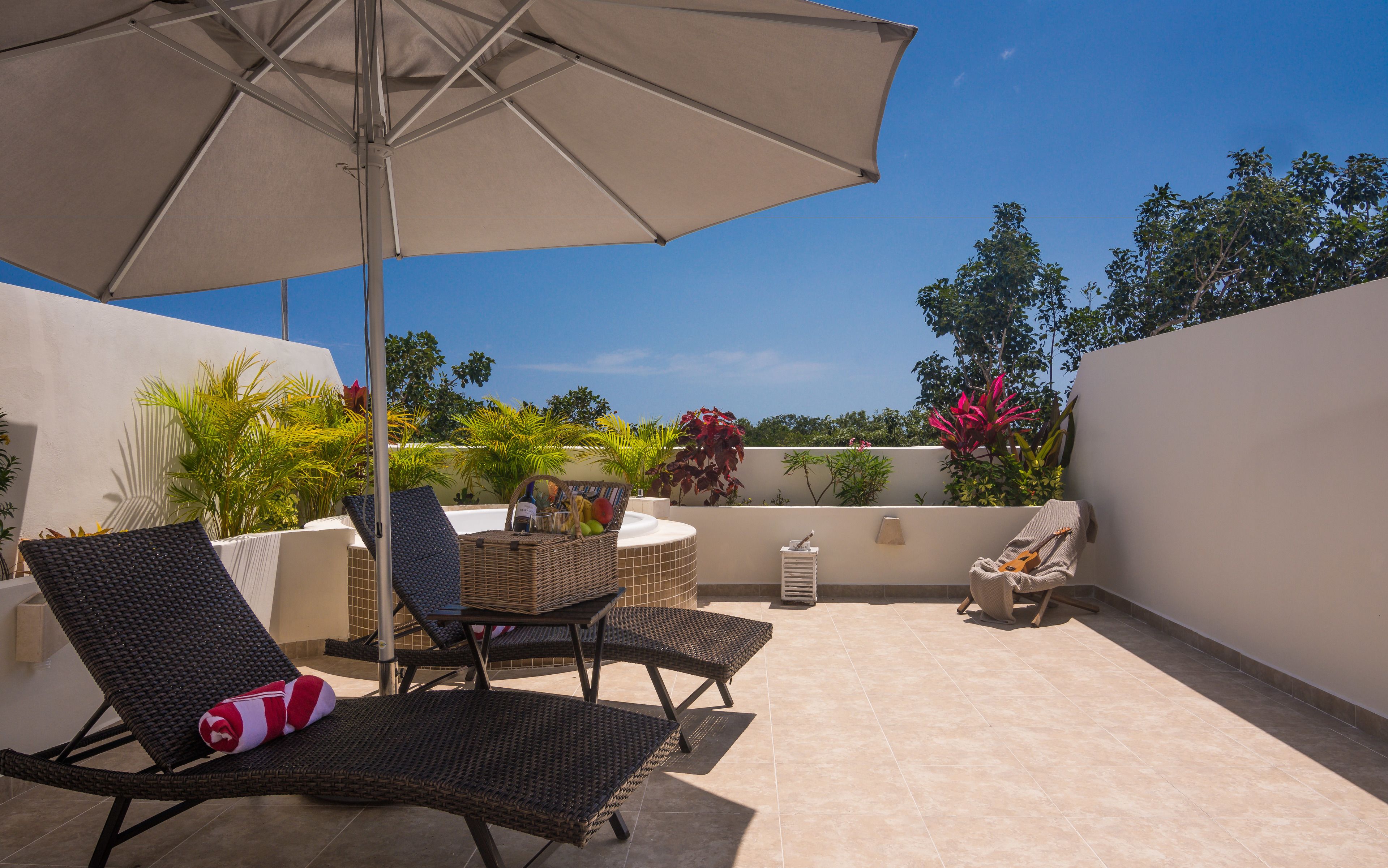 An outdoor patio with wicker chairs, a table, and an umbrella.
