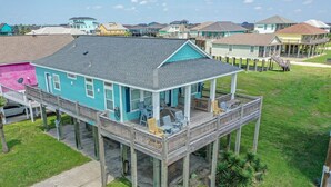 A two-story house with a wooden deck and a covered porch.
