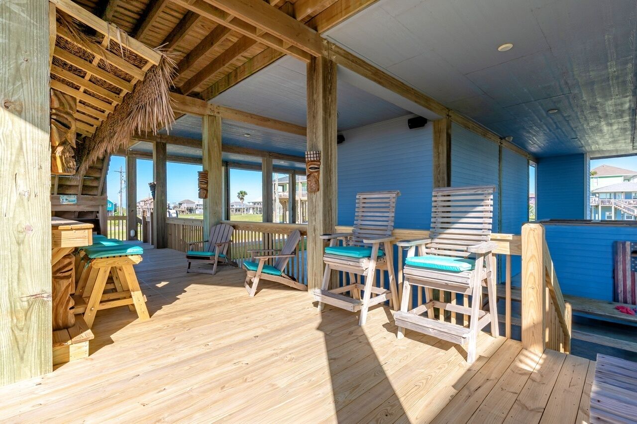 Une terrasse en bois avec des sièges extérieurs et une vue sur l’océan.