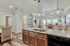 A kitchen with granite countertops, wooden cabinets, and a built-in dishwasher. - A La Playa 2 Bedroom Home by RedAwning (Port Bolivar)