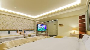 A hotel room with two beds, a television, a desk, and a lamp. - Better Future Homestay (Hualien City)
