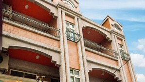 A multi-story building with balconies and a clock on the facade. - Better Future Homestay (Hualien City)