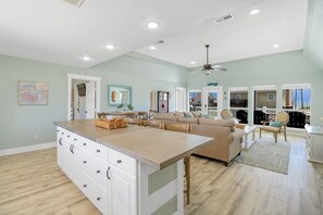 Amplia sala de estar con una isla grande, un sofá y una mesa de comedor.
