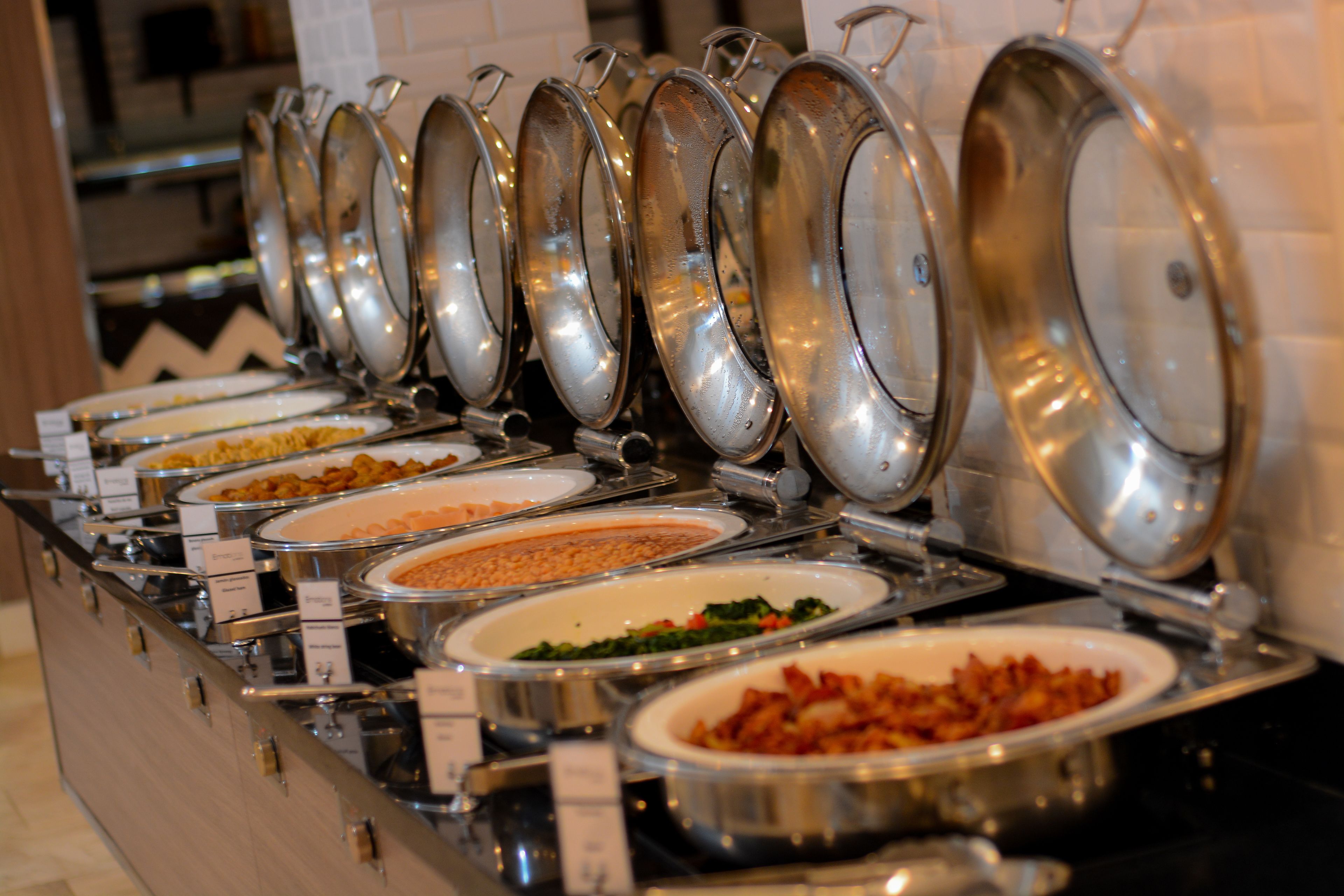 A buffet with multiple serving dishes, each with a lid.