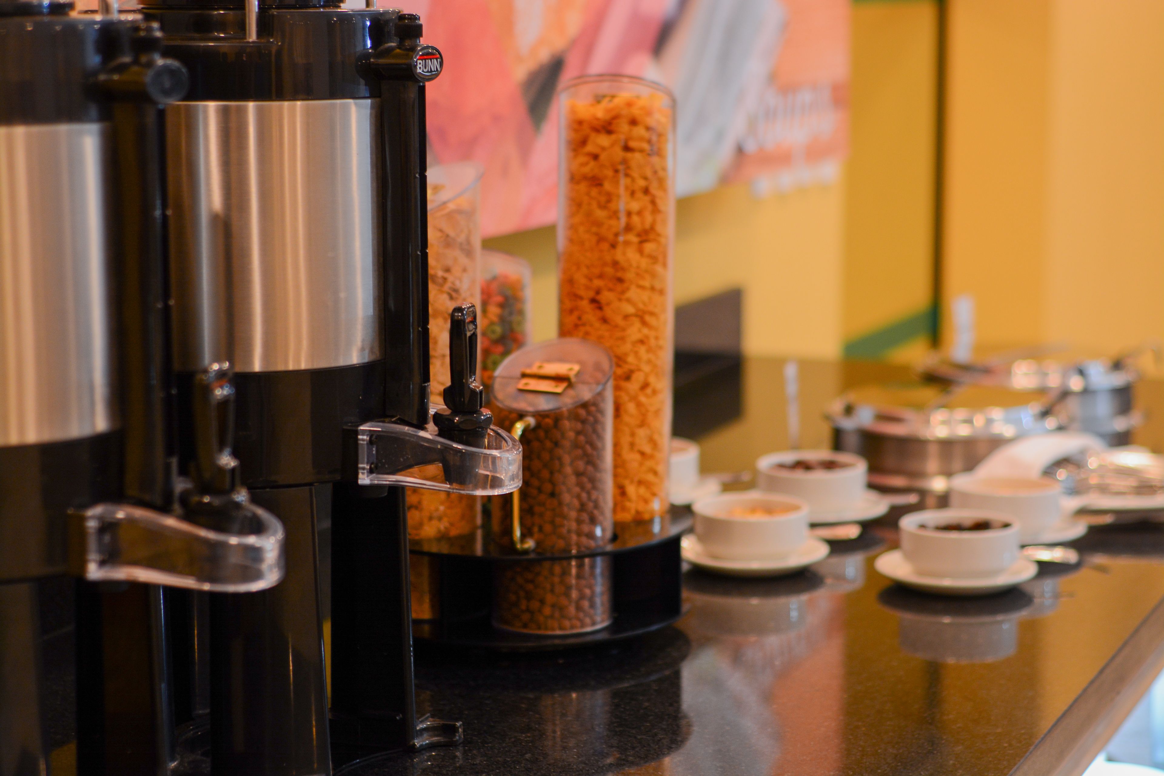 A coffee machine and various food containers on a counter.