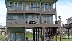 A multi-story building with balconies, a covered area, and a staircase. - The Sandy Cork 4 Bedroom Home by RedAwning (Port Bolivar)