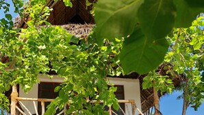 A two-story building with a wooden staircase leading to a balcony. - Promised Land Lodge (Kizimkazi)