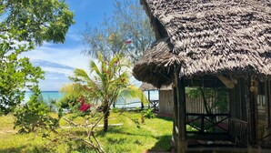 A thatched-roof structure with a view of the sea. - Promised Land Lodge (Kizimkazi)