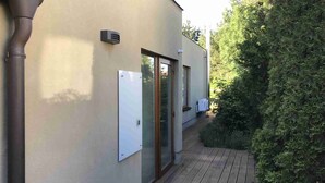 A building with a covered outdoor area, a door, and a window. - Luxury holiday home (Rosice)